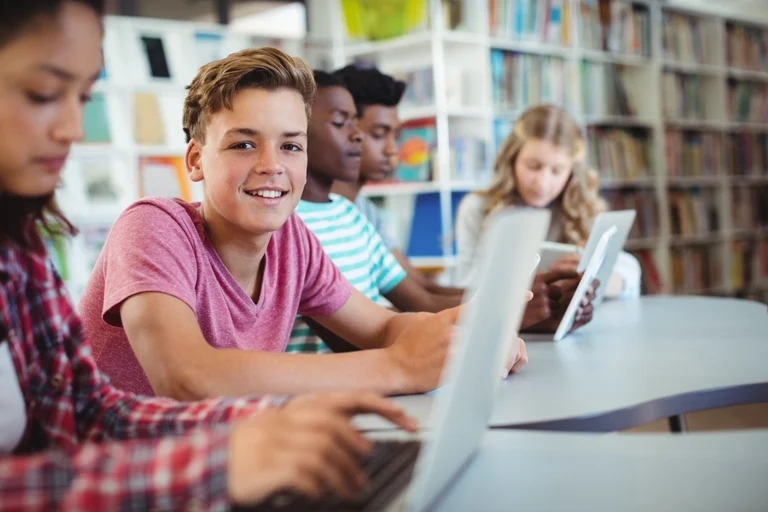 Schüler_innen lernen in der Bibliothek mit Laptops